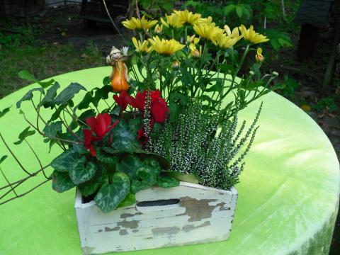 hölzerne Pfanlzschale mit bunten Blumen
