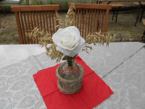weiße Rose mit Getreide in Vase auf Tisch